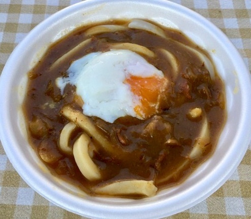 【カレーうどん】
・大人気のカレーうどん！
間違いのない旨さをお試し下さい！
※画像は温玉トッピングです
■価格：500円　※温玉トッピングは＋100円
■販売店舗：なすのまきうどん(ファンエリア)