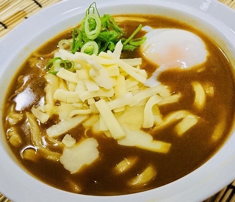 【熱々(暑々？)チーズカレーうどん】
・今回はイエローダービーということで、人気のカレーうどんを使った黄色づくしうどんにしてみました。黄色と言えばカレーにチーズ、卵(温玉)を乗せちゃいました!お子様も大好きなチーズがビヨ～ンと伸びるマイルドカレーうどんです‼　暑い時こそ熱いカレーを食べて熱く応援しましょう‼　また、オススメは夏の暑さにも負けないよう一味唐辛子一振りと、カレー用特製辛味オイルも用意しましたので、大人の方は是非‼
■価格：700円
■販売店舗：なすのまきうどん(バックスタンド)