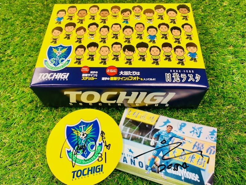 【日光ラスク(栃木SCオリジナルパッケージ)】
・2年ぶりに復活した日光の老舗和菓子店日昇堂様とのコラボ商品、「日光ラスク」の栃木SCオリジナルパッケージ。
日昇堂様の人気商品「日光ラスク」のシュガー・メイプル・抹茶の3パックセット。
もれなくすべての商品に選手の直筆サイン入りステッカーが封入されています。
さらに、大当たりは1/10程度の確率で直筆サイン入り生写真(非売品)が入っていますのでお楽しみに！
■価格：750円
■販売場所：ファンエリア内グッズ売店、ホームゴール裏グッズ売店
